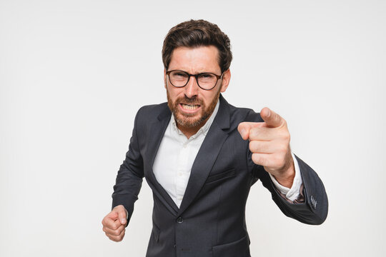 Studio, angry and portrait of business man in suit, pointing and accountability for you, shouting and reprimanding. White background, face and person with hand, scolding and serious of opinion