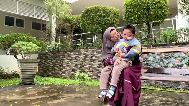 Muslim Mother Supporting Her chilf with Special Needs in the Park