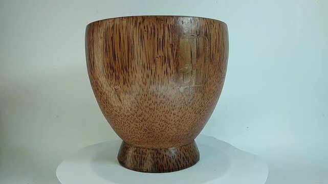 Wooden bowl, traditional, unique handicraft art with high aesthetic value, rotating on a stand with a white background.