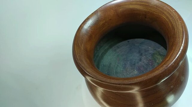Wooden jar, traditional, unique handicraft art with high aesthetic value, rotating close up view on white background.