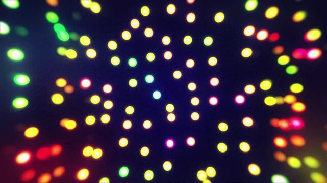 A dynamic motion graphics background featuring multicolored glowing dots combined with soft spotlight effects and floating particles