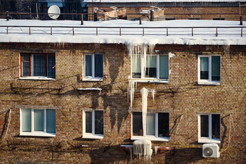 winter ice and icicles on old brick wall, urban decay scene