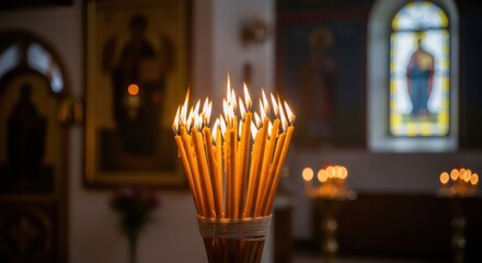 Lit church candles glowing brightly on an altar inside a Christian church. Spiritual devotion and prayer concept, for religious holidays.