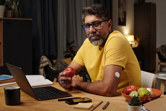 Portrait of man with insulin patch using laptop at home