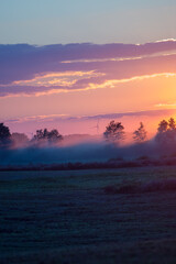 Krajobraz kolorowy zachód słońca mgła nad polami.  © Monika