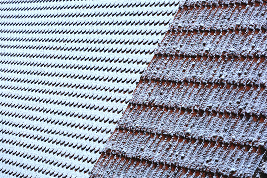 Snow covered roof with patterned tiles in winter Germany
