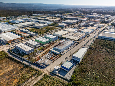 Aerial view of the industrial park reveals a tapestry of rooftops and roads, a testament to commerce amidst the Portuguese landscape, Albergaria-a-Velha, Portugal.