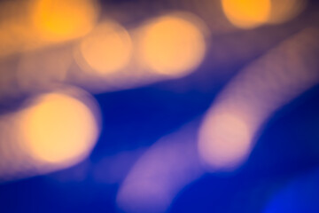 Artistic abstract background featuring soft golden bokeh against a deep blue background, creating a calming visual effect.