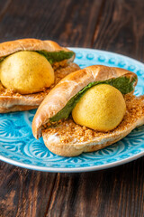 Authentic Vada Pav Indian street food with spicy chutney on rustic wooden background