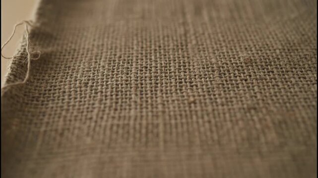 Burlap fabric craft material with natural woven texture and rough thread pattern in warm brown color for creative rustic design projects closeup