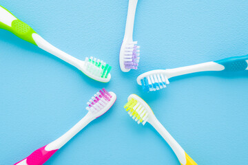 New colorful kid toothbrushes on light blue table background. Pastel color. Children teeth hygiene. Top down view.