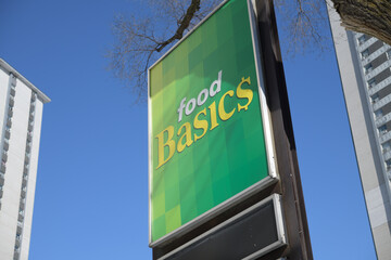 Fototapeta premium road pylon sign outside Food Basics, a discount supermarket chain, located here at 238 Wellesley St E, Toronto