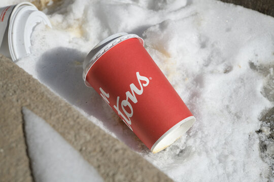 discarded Tim Hortons beverage cup on the snow, Toronto