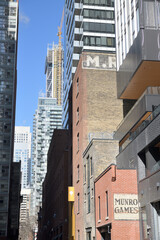 Fototapeta premium view north on St Nicholas St to vintage ghost signs (Munro Games) and the M. Rawlinson Limited, from Wellesley St W, Toronto