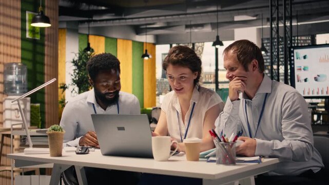 Team collaboration in a corporate office environment with laptop and reports on the table. Professionals reviewing KPI, income data and charts to support planning and decision making.