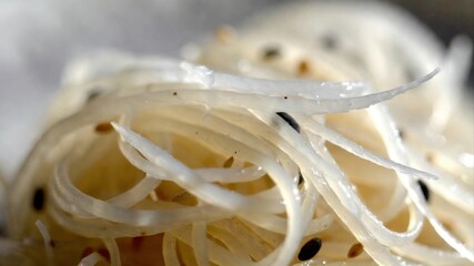 Close up rice noodles with sesame seeds and glossy texture