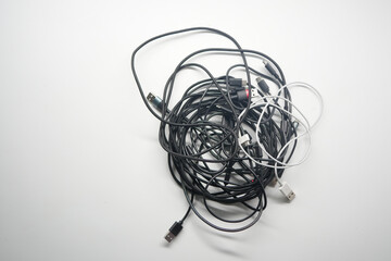 Multiple tangled charging cables on a white background