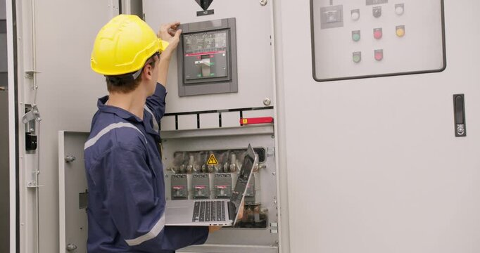 Caucasian engineer troubleshooting an electrical panel with a laptop, ensuring system performance. Focused and confident, this scene captures precision and expertise in a modern industrial setting,