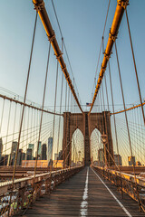 Large angle view of Brooklyn bridge in afternoon light, with tourists. Skyscrapers from Manhattan in the background. New York, USA