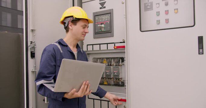 Caucasian engineer troubleshooting an electrical panel with a laptop, ensuring system performance. Focused and confident, this scene captures precision and expertise in a modern industrial setting,
