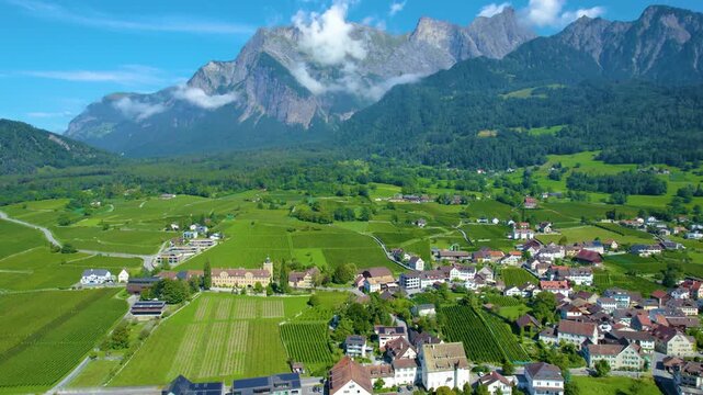 Aerial panoramic view around the old town city of Maienfeld  in Canton Sankt Gallen in Switzerland on a sunny spring day.