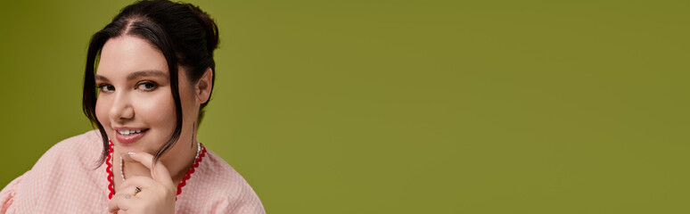 Stylish plus size woman showcases vibrant fashion against a fresh green backdrop