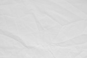 Top view of wrinkles on an unmade bed sheet after waking up in the morning.