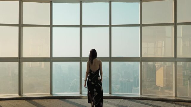 Asian stylish woman visiting in observation deck and modern glass window in skyscraper at Bangkok