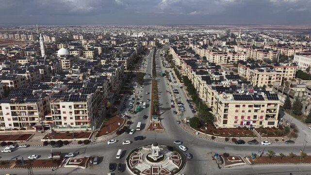 In Aleppo, Syria breathtaking aerial drone footage captures the urban skyline of the city under a dramatic sky. The video features high-angle views of residential neighborhoods and architecture, showc