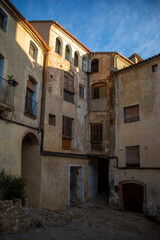 Typical houses in the historic center of Miravet, Tarragona, Catalonia, seen from below with golden morning light