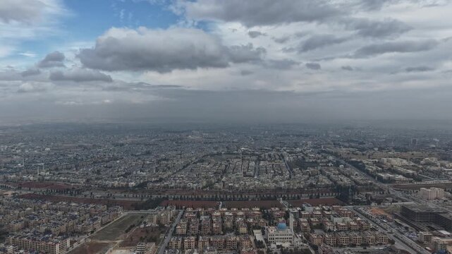 Cinematic time lapse of clouds moving over Aleppo city skyline. A breathtaking daytime time lapse showing dramatic clouds moving rapidly over the urban skyline of Aleppo, Syria