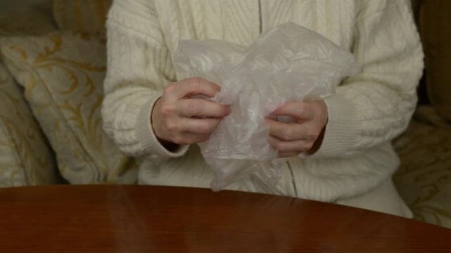 Hands squeezing and crumpling a thin nylon bag with sound