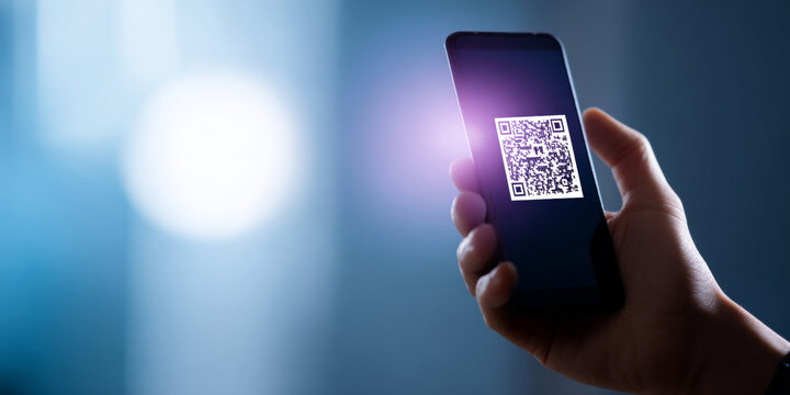 Hand holding smartphone with QR code