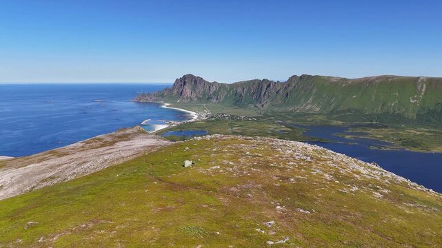 Forward turn drone flight above, Laupen mountain peak on Vesteralen, Vester&aring;len islands. Next to rocksrevealing Amazing Bleikmorenen nature reserve and Bleik village, beach. blue ocean. outdoor travel