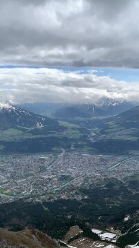 View on Innsbruck and the river Inn from mountains in April. Panorama view from the Nordkette top to Innsbruck and mountain range, Innsbruck, Tirol, Austria. Aerial view of the city of Innsbruck. 