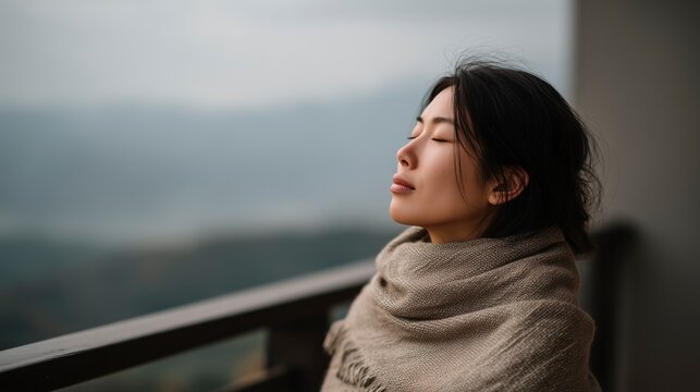 Woman enjoys fresh air on balcony while embracing senses in nature during overcast day without distractions in mountain area