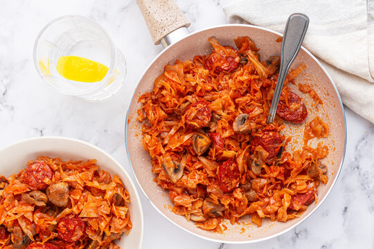 Bigos, Polish dish bigos, on the table, pan with stewed meat, with cabbage, chorizo sausages, mushrooms, homemade, without people,