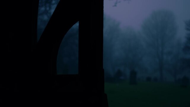 Lonely Graveyard on foggy day though view of lych gate