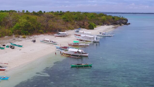 Aerial view of small boats moored near a tropical island sandbank