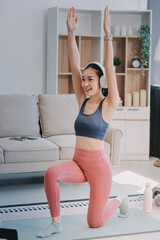 Young Asian sporty attractive people practicing yoga lesson with instructor. Asia group of women exercising healthy lifestyle in fitness studio. Sport activity, gymnastics or ballet dancing class.