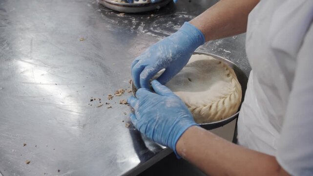 Baker sealing pie crust by hand.