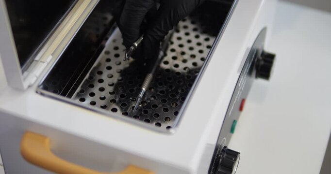 A cosmetic metal instrument is transferred to dry heat for sterilization. Video with sound.