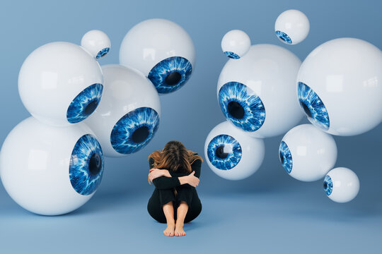Woman sitting on studio floor surrounded by floating 3D eyeballs