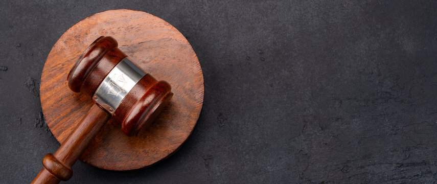 Judge's gavel on the black stone table
