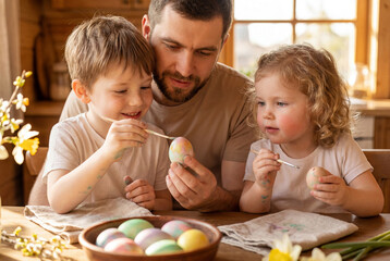 Naklejka premium Father and Children Painting Easter Eggs Together