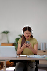 Young woman wearing headphone listening music on smartphone