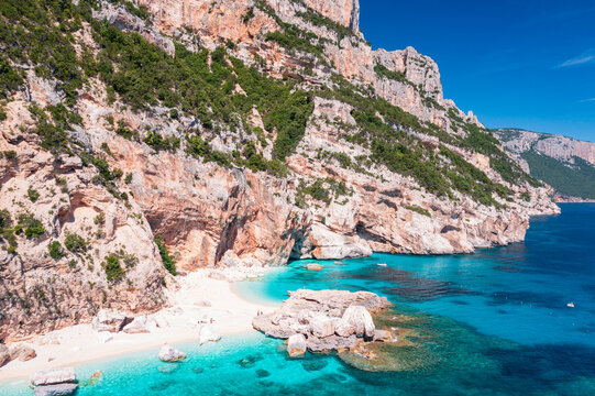 Aerial view of Cala Mariolu, stunning turquoise bay with white limestone cliffs and crystal clear water along the Baunei Coast, Gulf of Orosei, Sardinia, Italy.