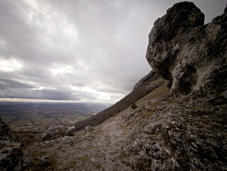 Paesaggio montano, campi coltivati e fiume nella valle illuminata dal sole