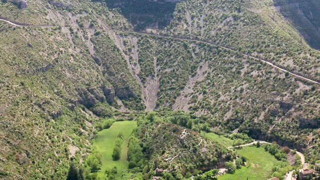 Quelques maisons &eacute;parpill&eacute;es le long de la rivi&egrave;re, au fond du canyon, pr&egrave;s d'un m&eacute;andre ass&eacute;ch&eacute;. Navacelles, H&eacute;rault, France.