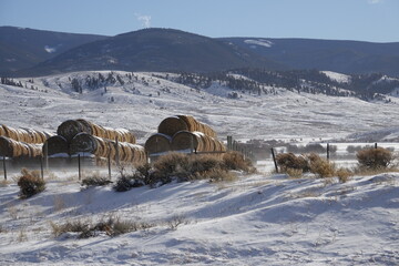 snow covered hay bales stacked in the field